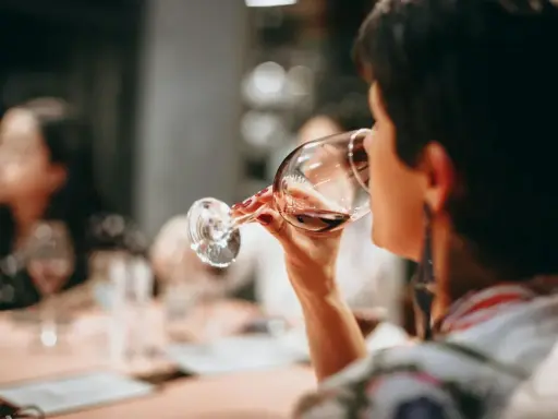 Mujer disfrutando de diferentes tipos de vino en una cata.
