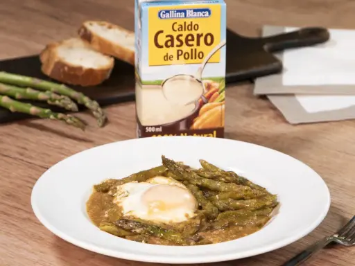 Espárragos esparragados con huevo frito, pan y caldo de pollo Gallina Blanca.