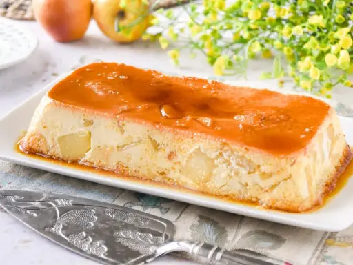 Delicioso pudin de manzana con caramelo líquido, trozos de manzana visibles en su interior.