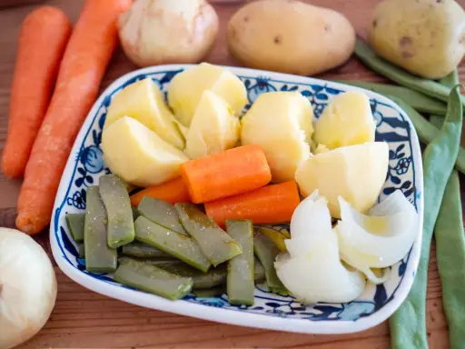 Plato de hervido valenciano con patatas, zanahorias, judías verdes y cebolla.