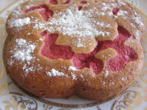 Bizcocho de fresa con azúcar glas espolvoreado, con un diseño interior de color rosa vibrante.