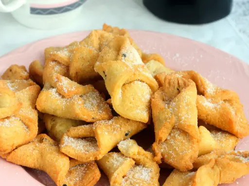 Pestiños antiguos espolvoreados con azúcar, listos para disfrutar. Una delicia tradicional.