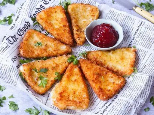 Queso frito crujiente servido con mermelada de frutos rojos.