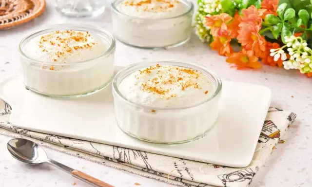 Delicioso mousse de yogur en vasitos de cristal, espolvoreado con canela. Un postre ligero y refrescante.
