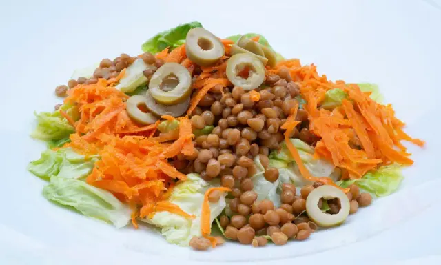 Ensalada de lentejas con zanahoria rallada y aceitunas, un plato fresco y saludable, estilo Arguiñano.