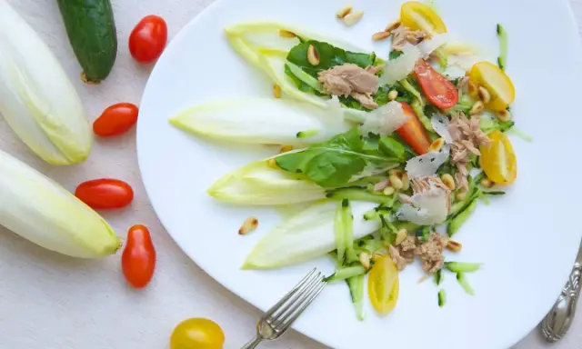 Deliciosa ensalada de endivias con atún, tomate, pepino y piñones. Un plato fresco y ligero.