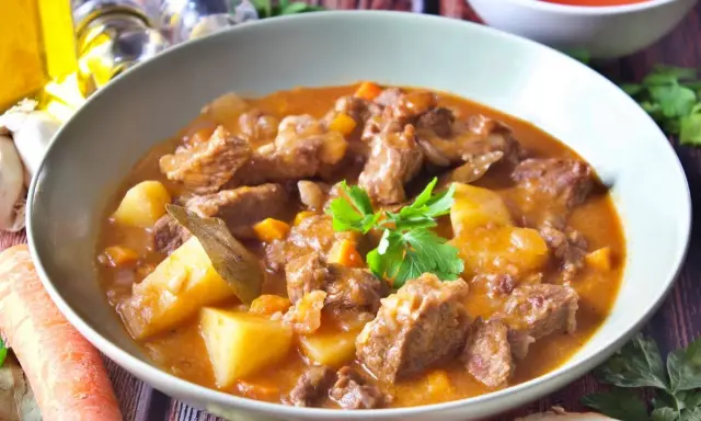 Un reconfortante plato de patatas guisadas con trozos de carne tierna, zanahorias y patatas en una rica salsa.