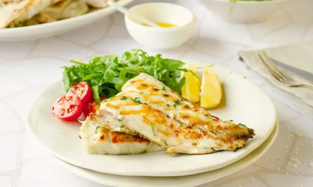 Deliciosa corvina a la plancha, servida con rúcula fresca, tomates cherry y gajos de limón. Un plato ligero y sabroso.