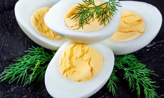 Huevos duros perfectamente cocidos y fáciles de pelar, adornados con eneldo fresco.