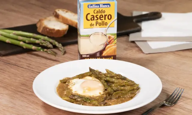 Espárragos esparragados con huevo frito, pan y caldo de pollo Gallina Blanca.