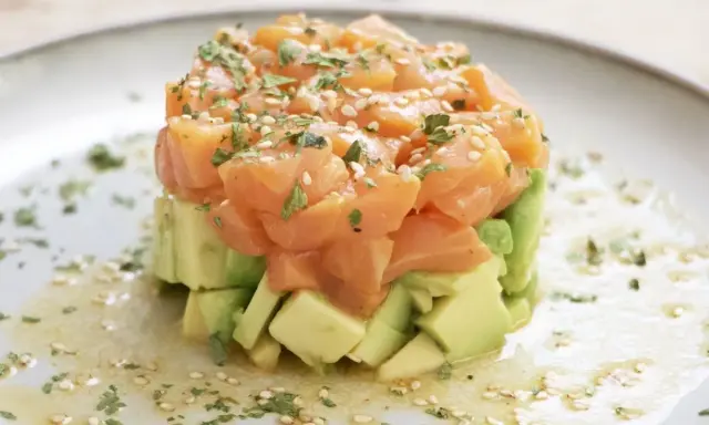 Delicioso tartar de salmón y aguacate, coronado con semillas de sésamo y perejil fresco.