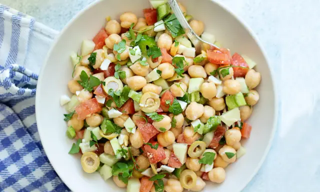 Ensalada garbanzos fresca con tomate, pepino, aceitunas y perejil. Un plato ligero y nutritivo.