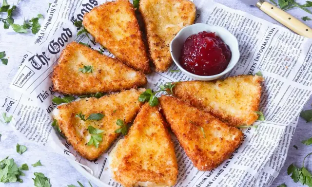 Queso frito crujiente servido con mermelada de frutos rojos.