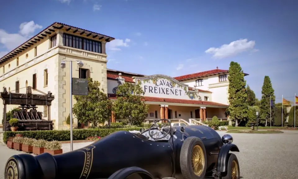Un coche clásico negro frente a las Cavas Freixenet en Penedès.