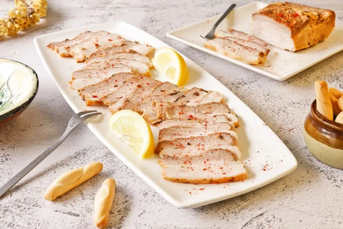 Chicharr&oacute;n de C&aacute;diz en lonchas, servido con lim&oacute;n y picos. Un plato que evoca el sabor de la costa gaditana.