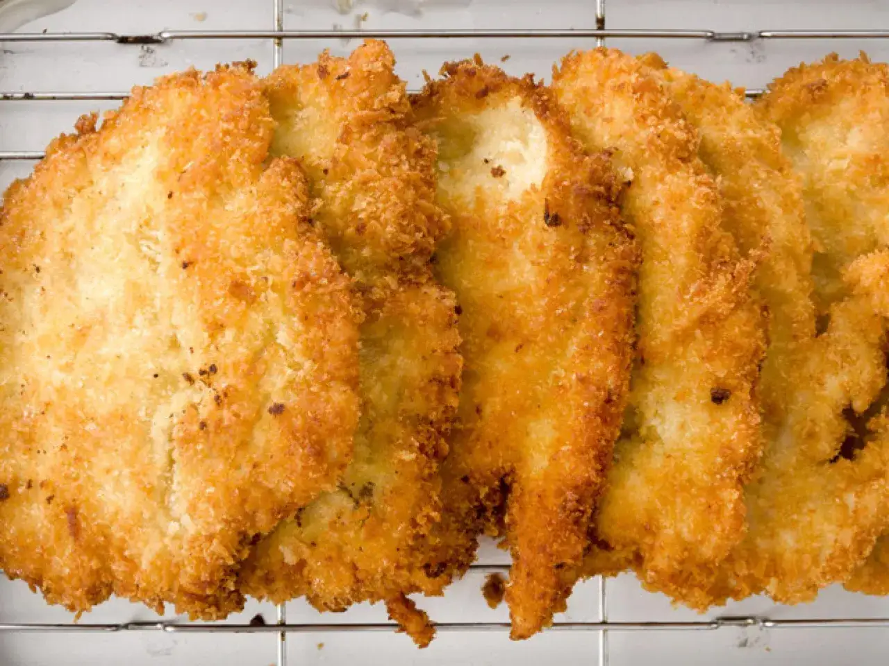 Filetes dorados de pechuga empanada, crujientes y listos para disfrutar.
