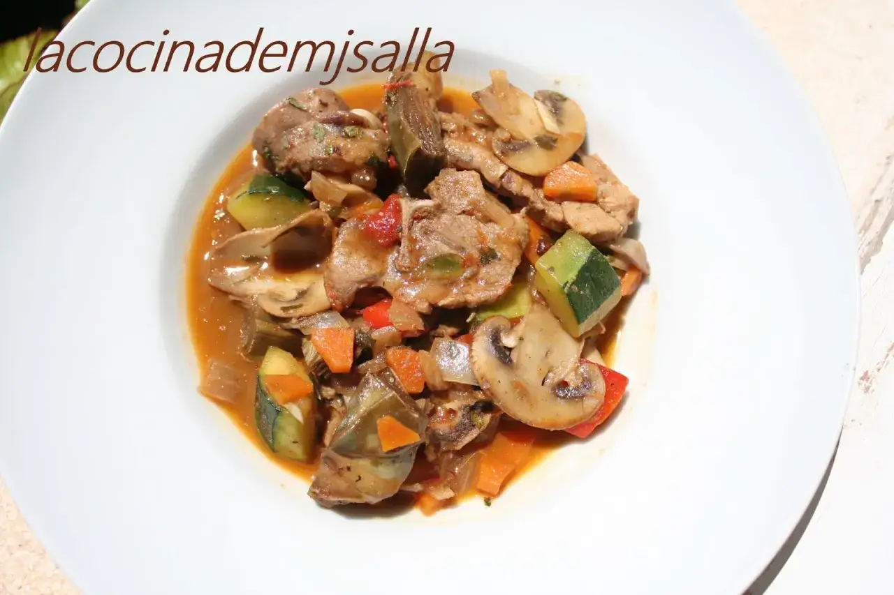 Delicioso lechazo guisado con verduras: champi&ntilde;ones, calabac&iacute;n, zanahoria y pimientos en una salsa sabrosa.