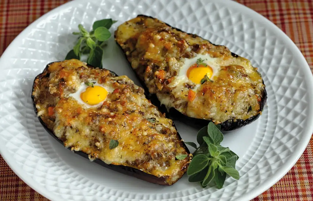 Berenjenas rellenas de la abuela, horneadas con huevo y queso gratinado, un plato casero que evoca recuerdos.