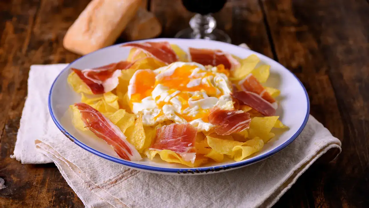 Plato con patatas fritas, jam&oacute;n serrano y huevos estrellados. Un manjar espa&ntilde;ol.