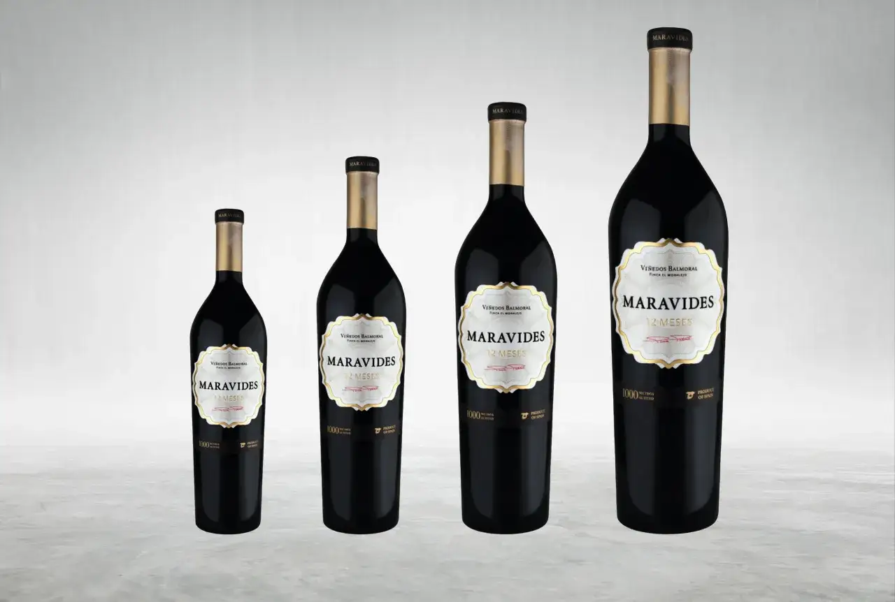 Cuatro botellas de vino tinto Maravides de diferente medida, todas con etiqueta blanca y dorada.
