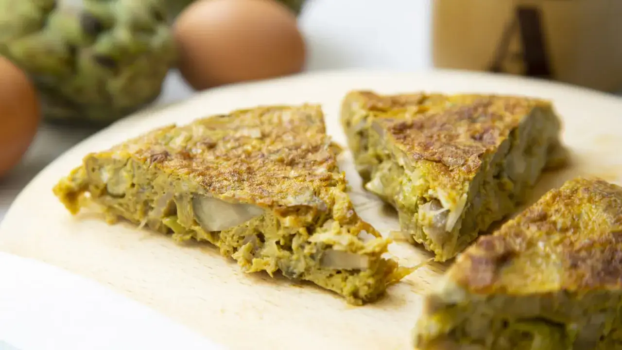 Deliciosa tortilla de alcachofas, con trozos tiernos y dorados, lista para disfrutar.