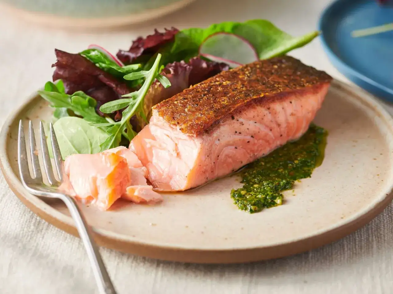 Un jugoso salm&oacute;n a la plancha con piel crujiente, acompa&ntilde;ado de una ensalada fresca y salsa verde vibrante.