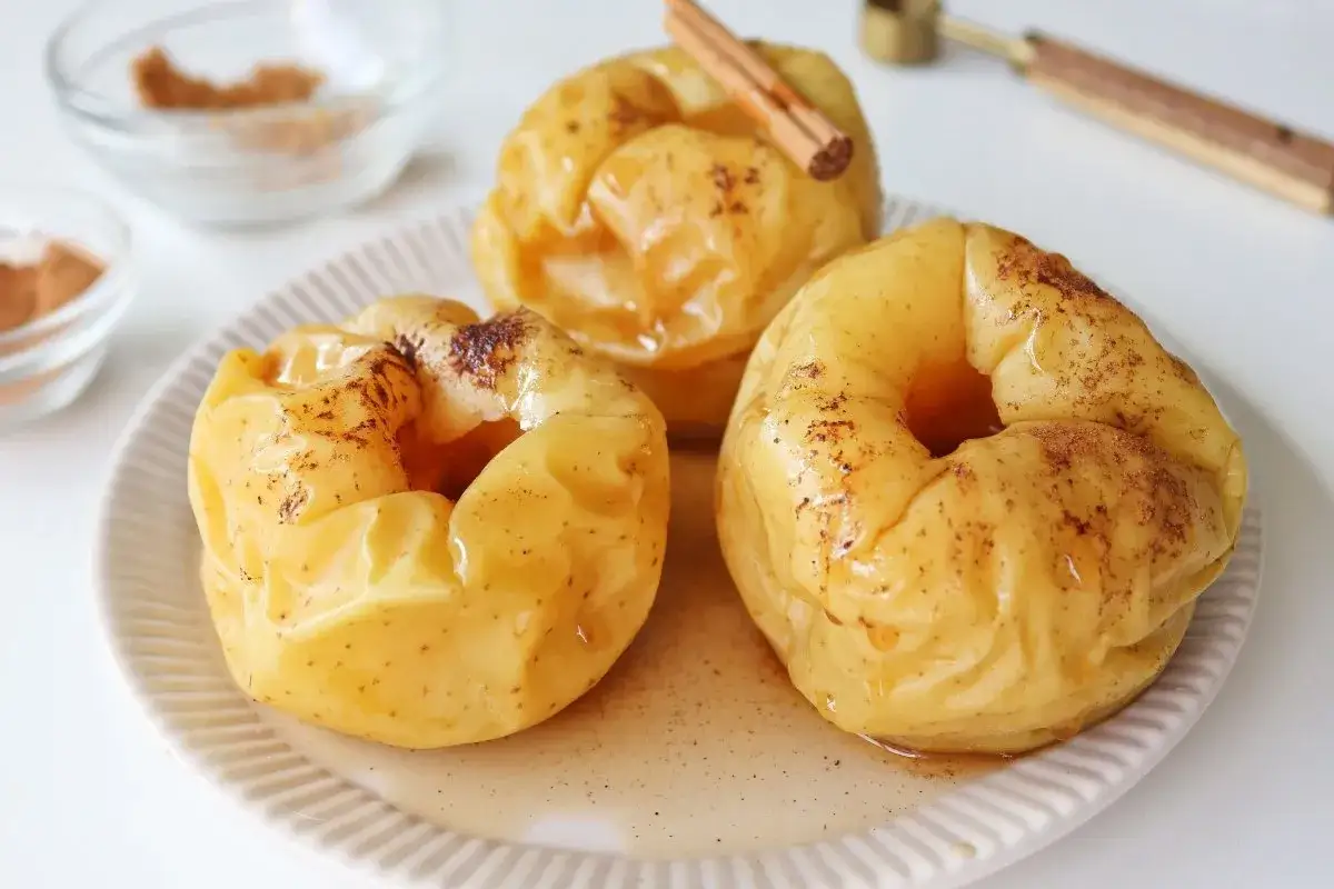 Manzanas asadas al microondas, tiernas y dulces, espolvoreadas con canela y ba&ntilde;adas en su propio jugo.