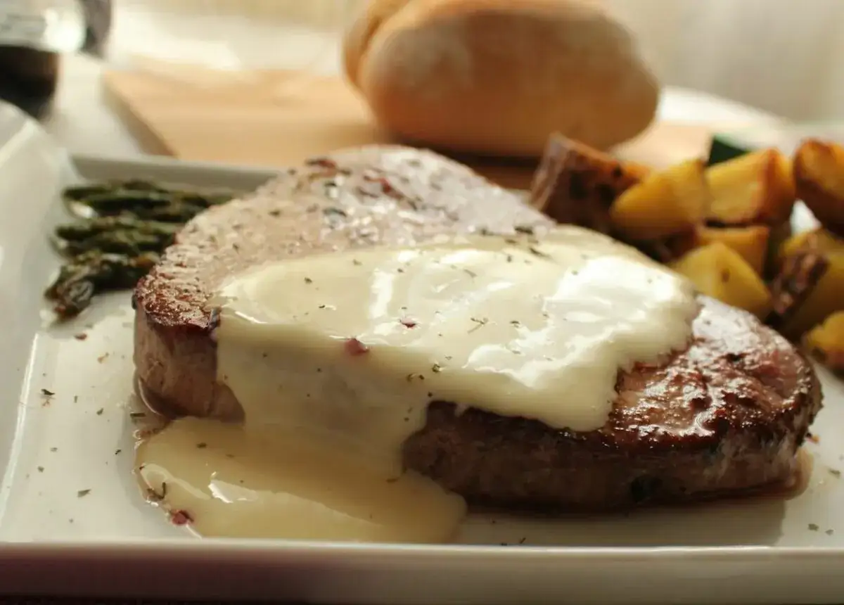 Escalopines de ternera jugosos con salsa cremosa, acompa&ntilde;ados de esp&aacute;rragos y patatas asadas.