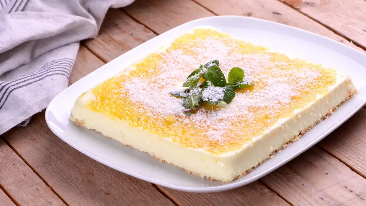 Deliciosa tarta de pi&ntilde;a, cubierta con coco rallado y decorada con menta fresca.