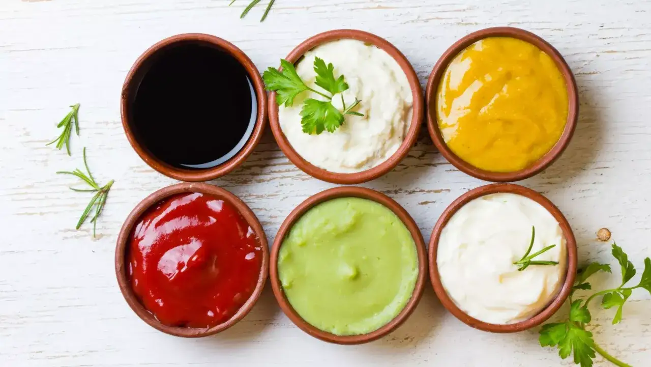 Seis salsas en cuencos de barro: k&eacute;tchup, mayonesa, mostaza, aguacate, salsa negra y alioli. &iquest;Cu&aacute;nto dura el alioli casero en la nevera?
