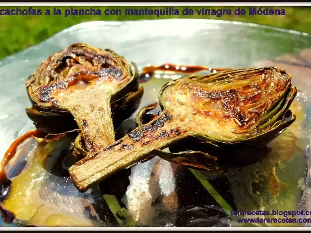 Dos mitades de alcachofas a la plancha, doradas y jugosas, servidas con una reducci&oacute;n de vinagre de M&oacute;dena.