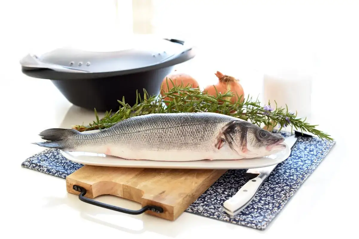 Lubina a la sal Thermomix: pescado fresco, romero, cebolla y sal listos para cocinar.