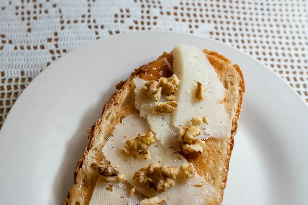 Tostada con queso, nueces y un toque de mermelada de aceite de oliva.