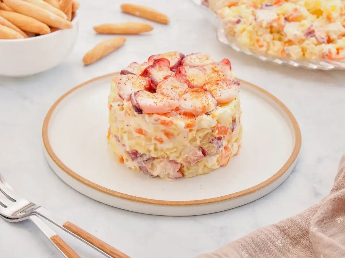 Deliciosa ensaladilla de pulpo, con patatas, zanahoria y huevo, coronada con trozos de pulpo tierno.