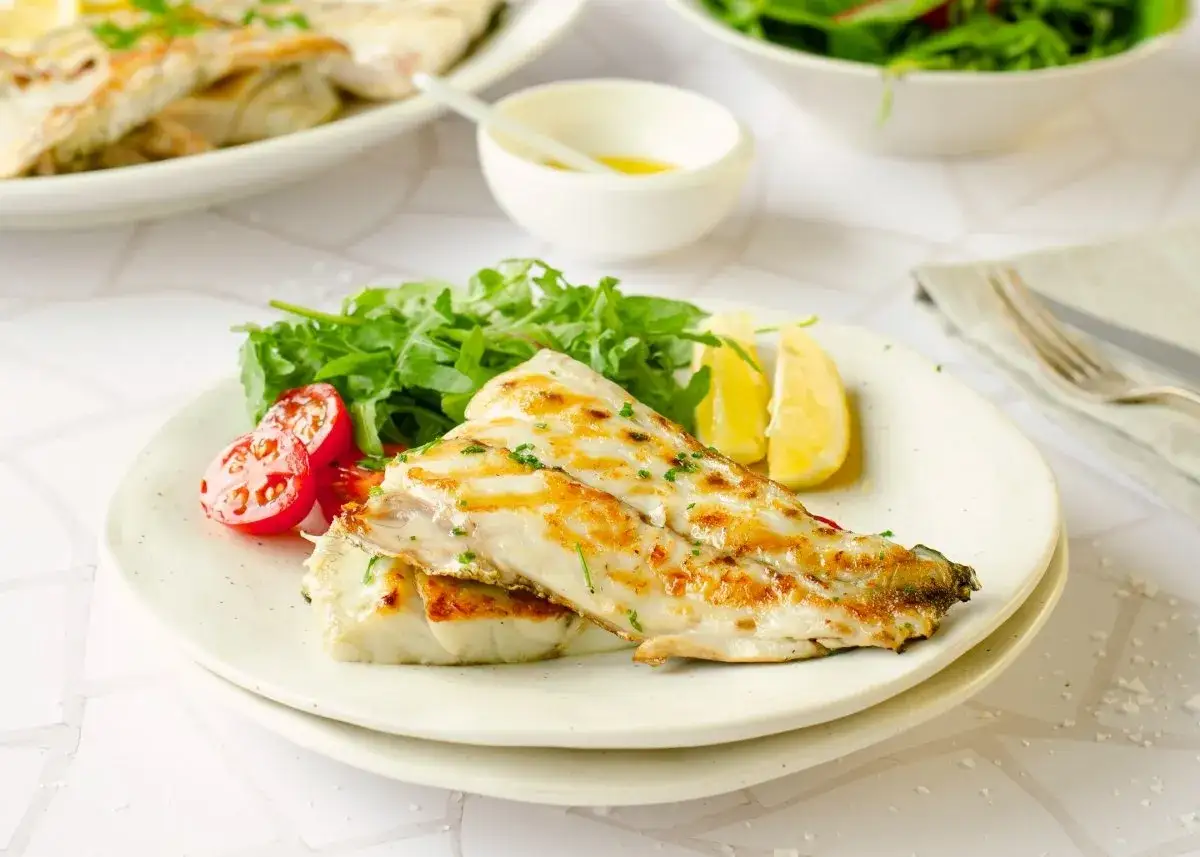 Deliciosa corvina a la plancha, servida con ensalada verde, tomates cherry y gajos de lim&oacute;n. Un plato ligero y sabroso.