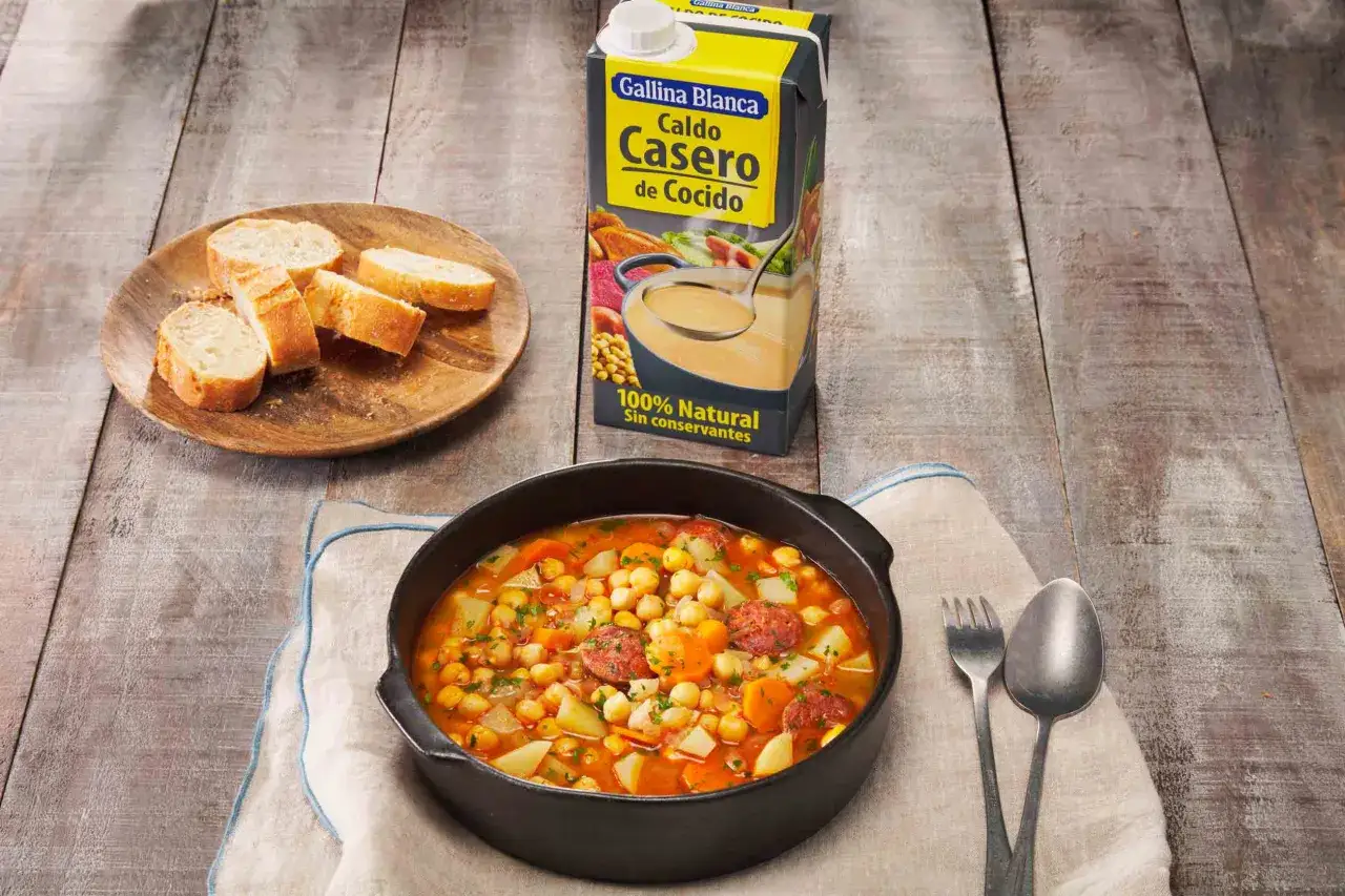 Un reconfortante cocido de garbanzos con chorizo y patatas, acompa&ntilde;ado de pan y caldo casero.