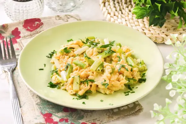 Revuelto de ajetes con perejil fresco, servido en un plato verde claro.