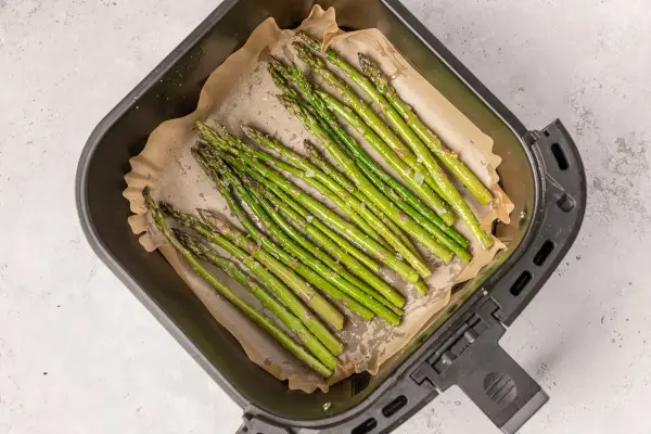 Espárragos frescos listos para cocinar en la airfryer, con un toque de sal y aceite.