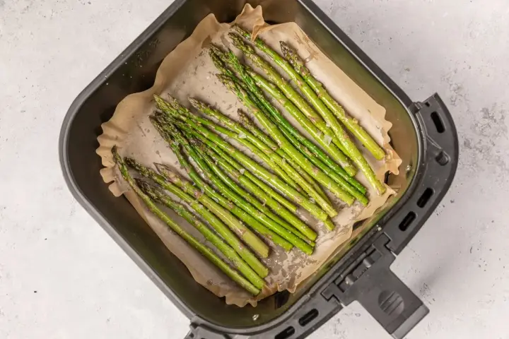 Espárragos frescos listos para cocinar en la airfryer, con un toque de sal y aceite.